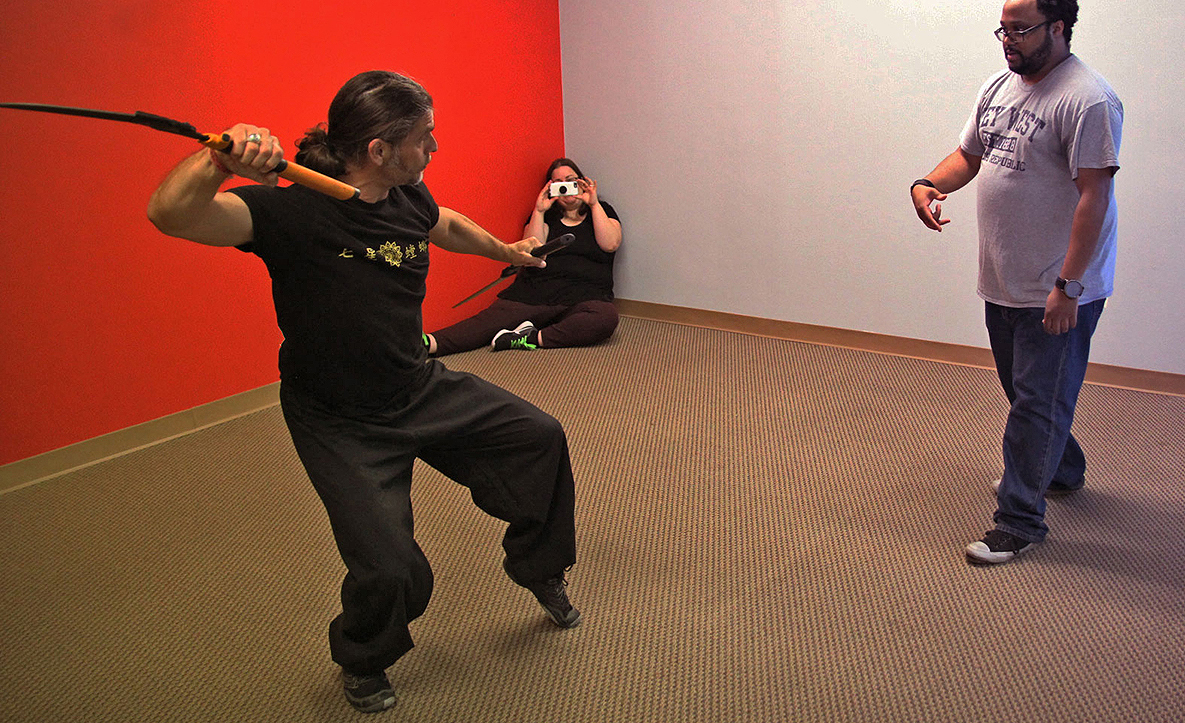 Sifu Thomas Leverett posing for an improvised weapon fight sequence with broken-in-half shears.  Supervising Storyboard Artist Julie Olson and Director Willis Bulliner take note at the Austin-based Powerhouse Animation Studios.